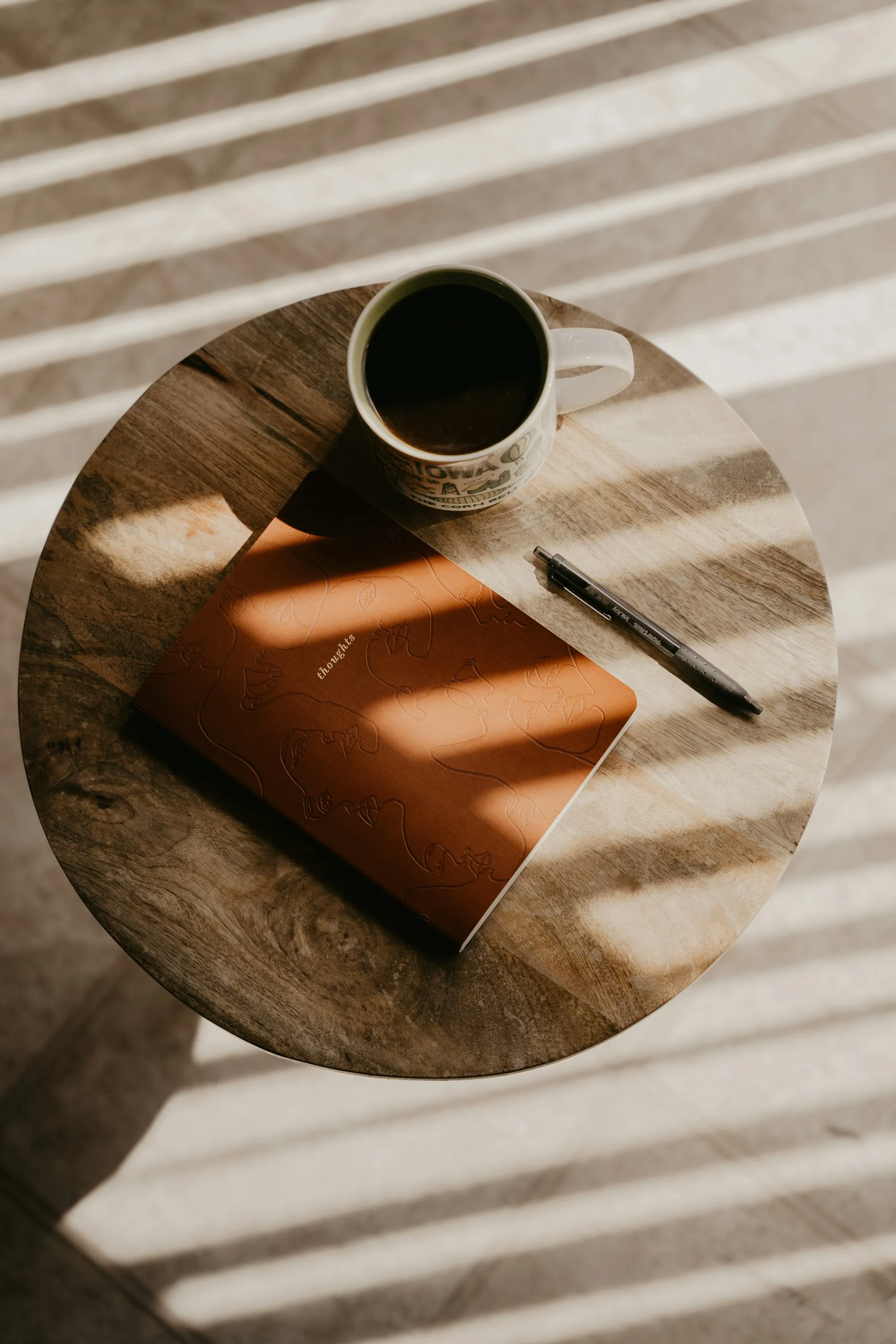 A notebook and a cup of coffee in afternoon light