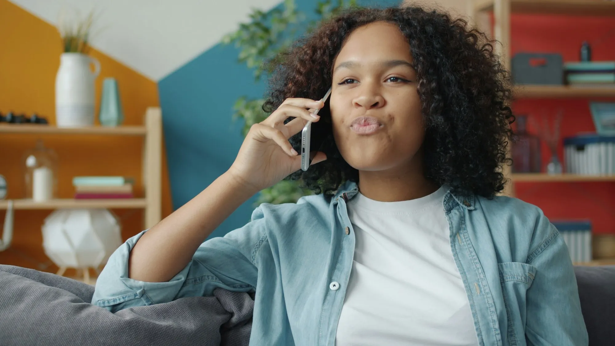 A woman smiling while talking on the telephone at home