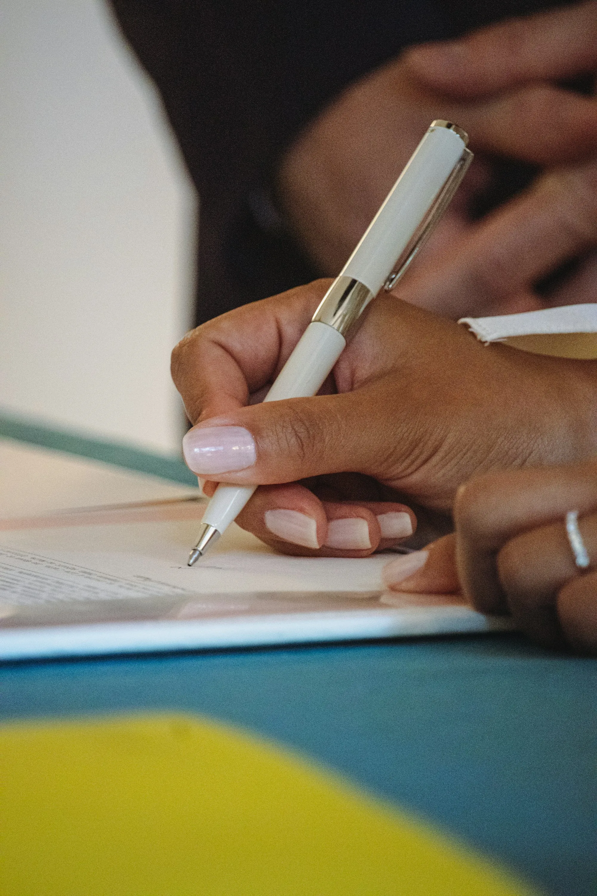 A hand writing on a sheet of paper with a pen
