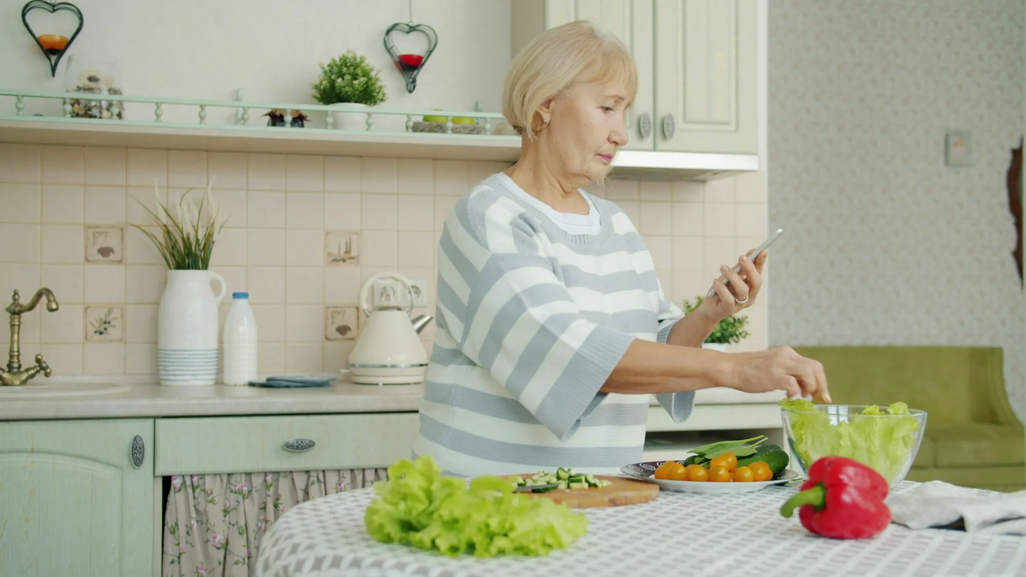 An older woman preparing a salad in her kitchen